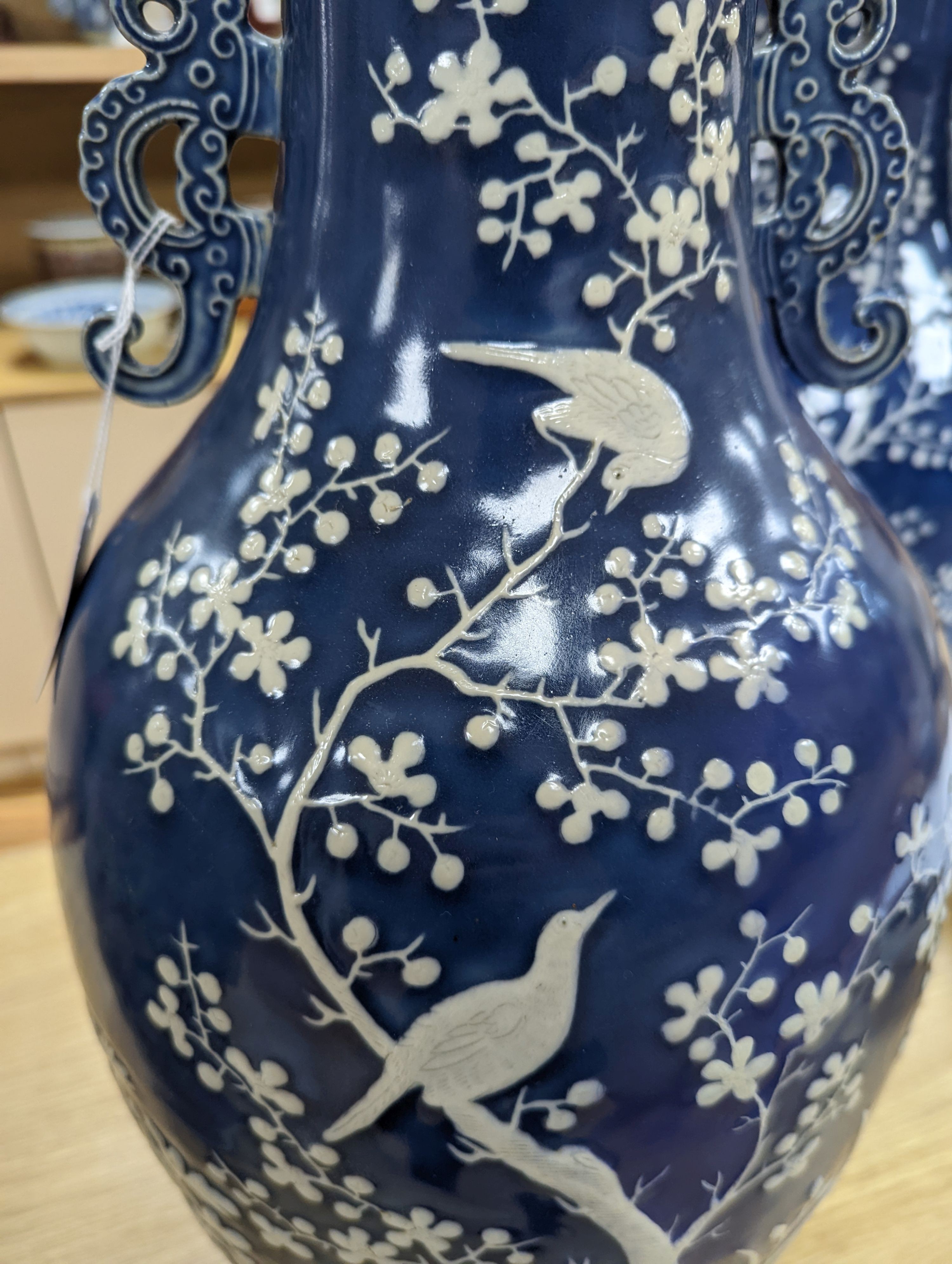 A pair of large 19th century Chinese slip decorated blue ground vases, restored, 59cm